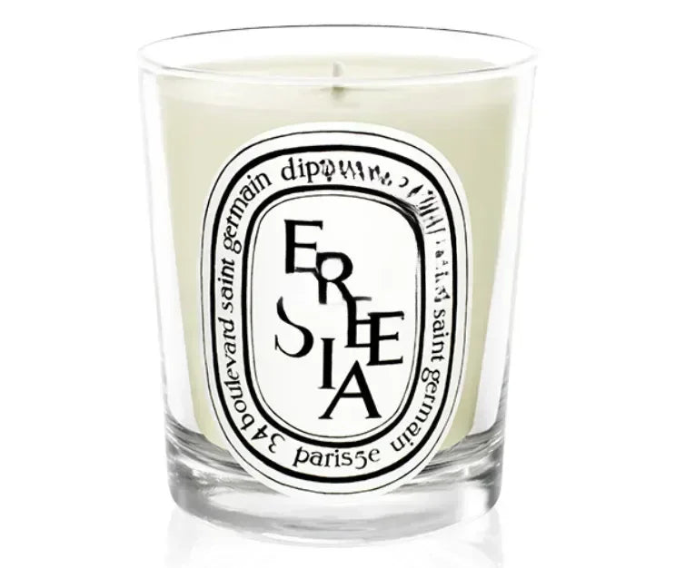 Freesia scented candle in a glass jar on white background