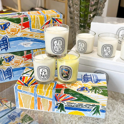 five decorative candles  in a white glass jar with the candles box on the table 
