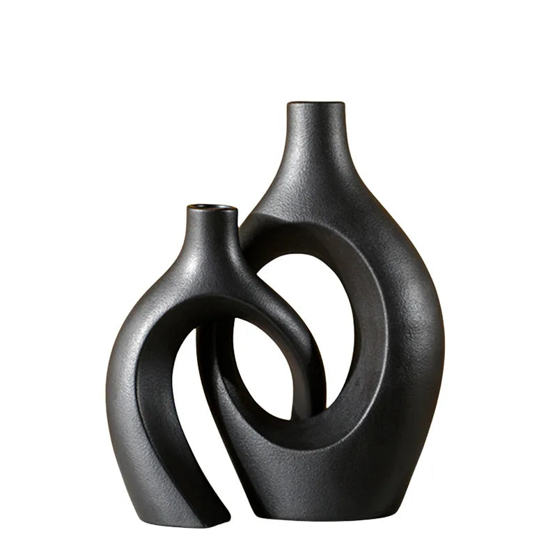 Black ceramic vase with textured organic design placed on a white background.