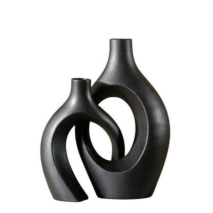 Black ceramic vase with textured organic design placed on a white background.