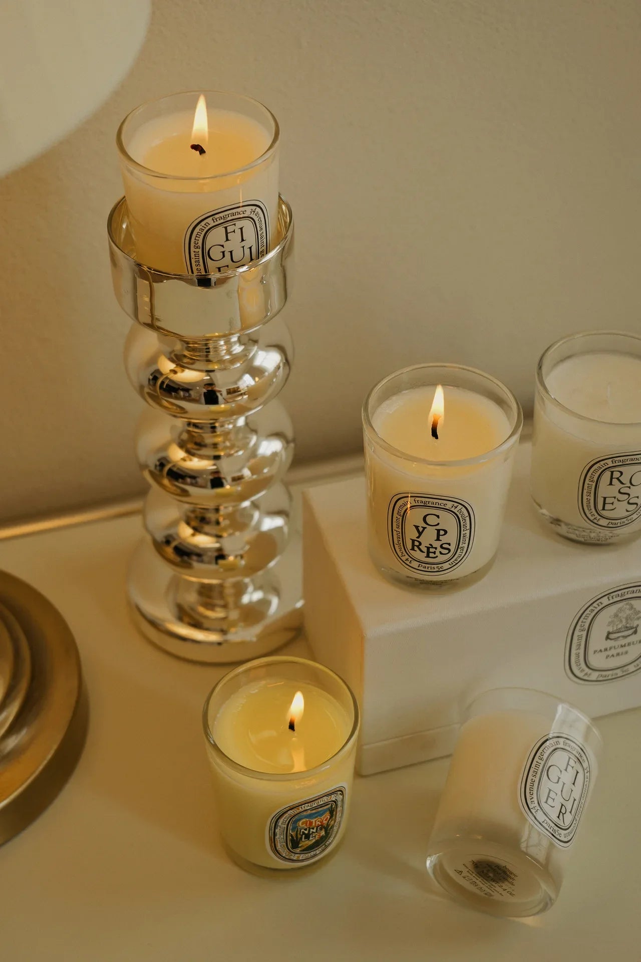 three decorative candles  in a white glass jar decorating a table 