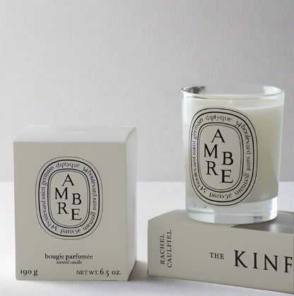 Amber scented candle in a glass jar on white background