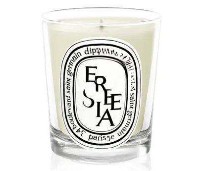 Freesia scented candle in a glass jar on white background

