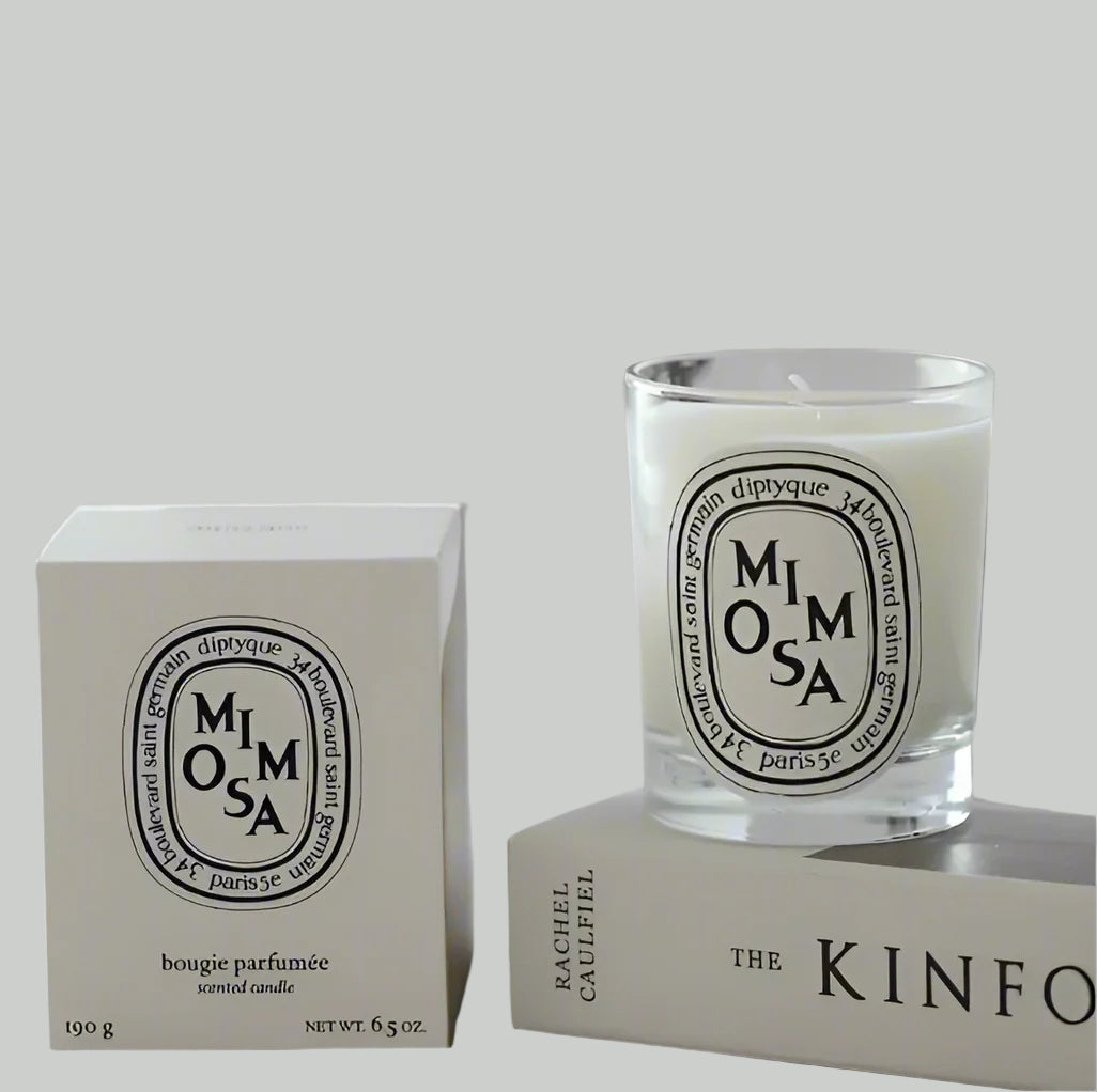 Mimosa scented candle in a glass jar and box of the candle on white background
