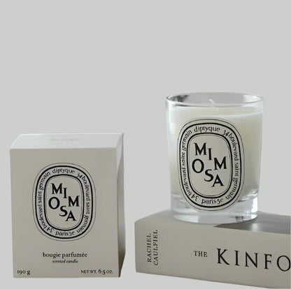 Mimosa scented candle in a glass jar and box of the candle on white background
