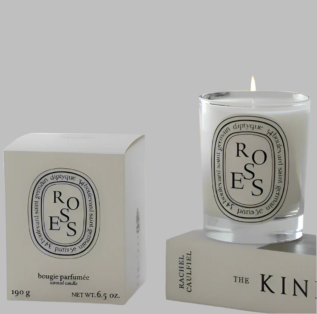 Roses scented candle in a glass jar on white background