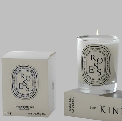 Roses scented candle in a glass jar on white background