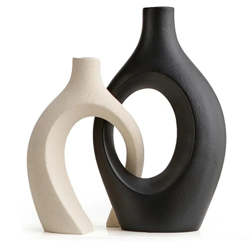 White and black minimalist ceramic vase displayed on a neutral background.