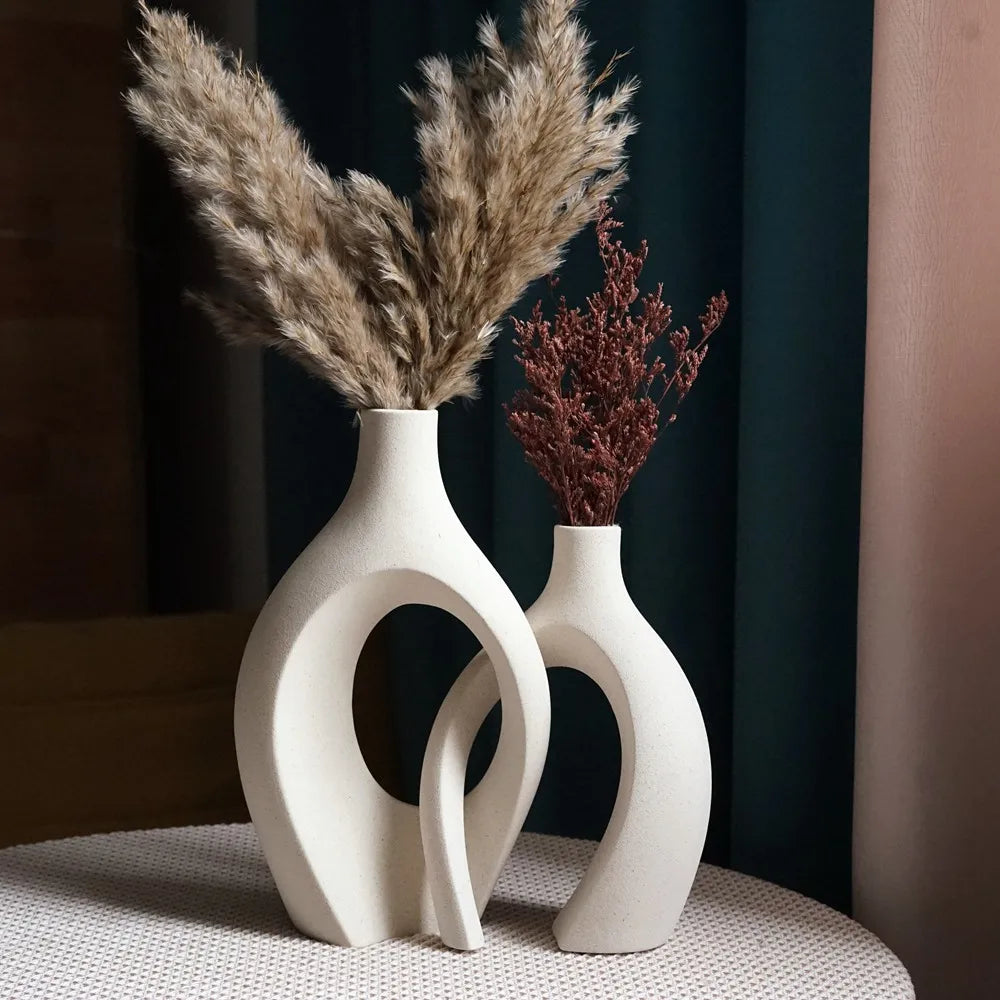 white ceramic vase with a large floral relief on the front placed on a white surface